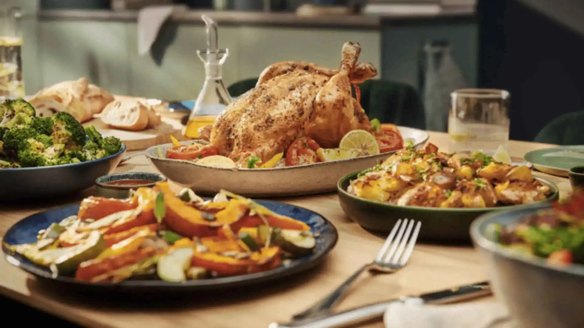 Philips Airfryer izcilība: Perfekti apbrūnināta vesela cepta vistas fileja, ko papildina veselīgi salāti un svaigi cepta maize gardai ģimenes maltītei.