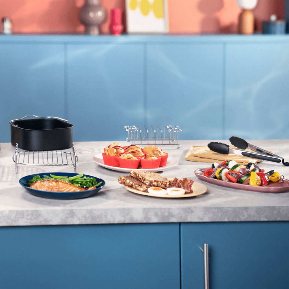 Uz letes novietots Philips divu grozu gaisa fritieri ar piederumiem un traukiem.