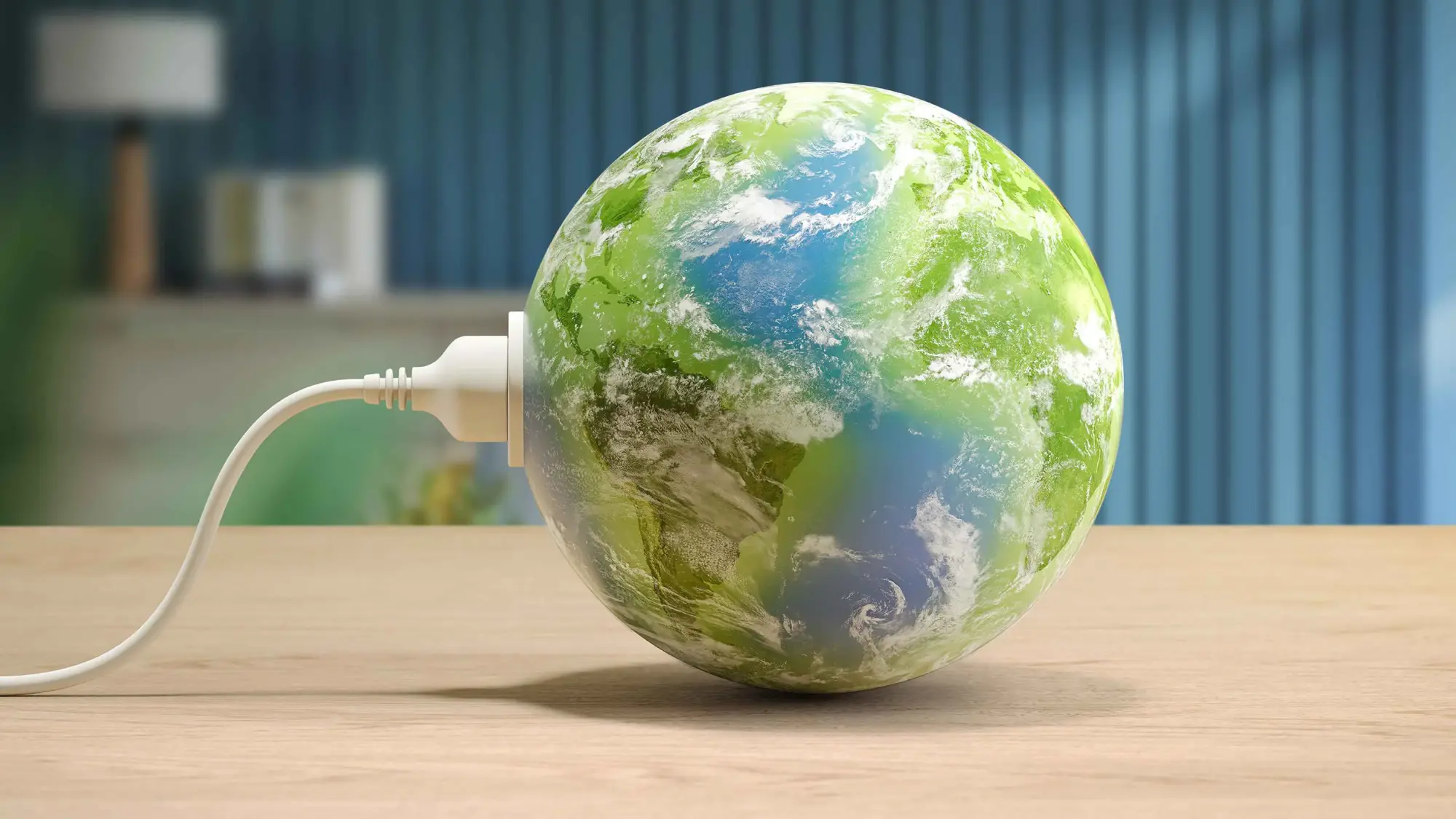 Zemeslodes tuvplāns ar elektrības kontaktdakšu — Philips Climate Care simbolizē tīru enerģiju. Zaļā, zilā sfēra atrodas uz gaiša koka virsmas.