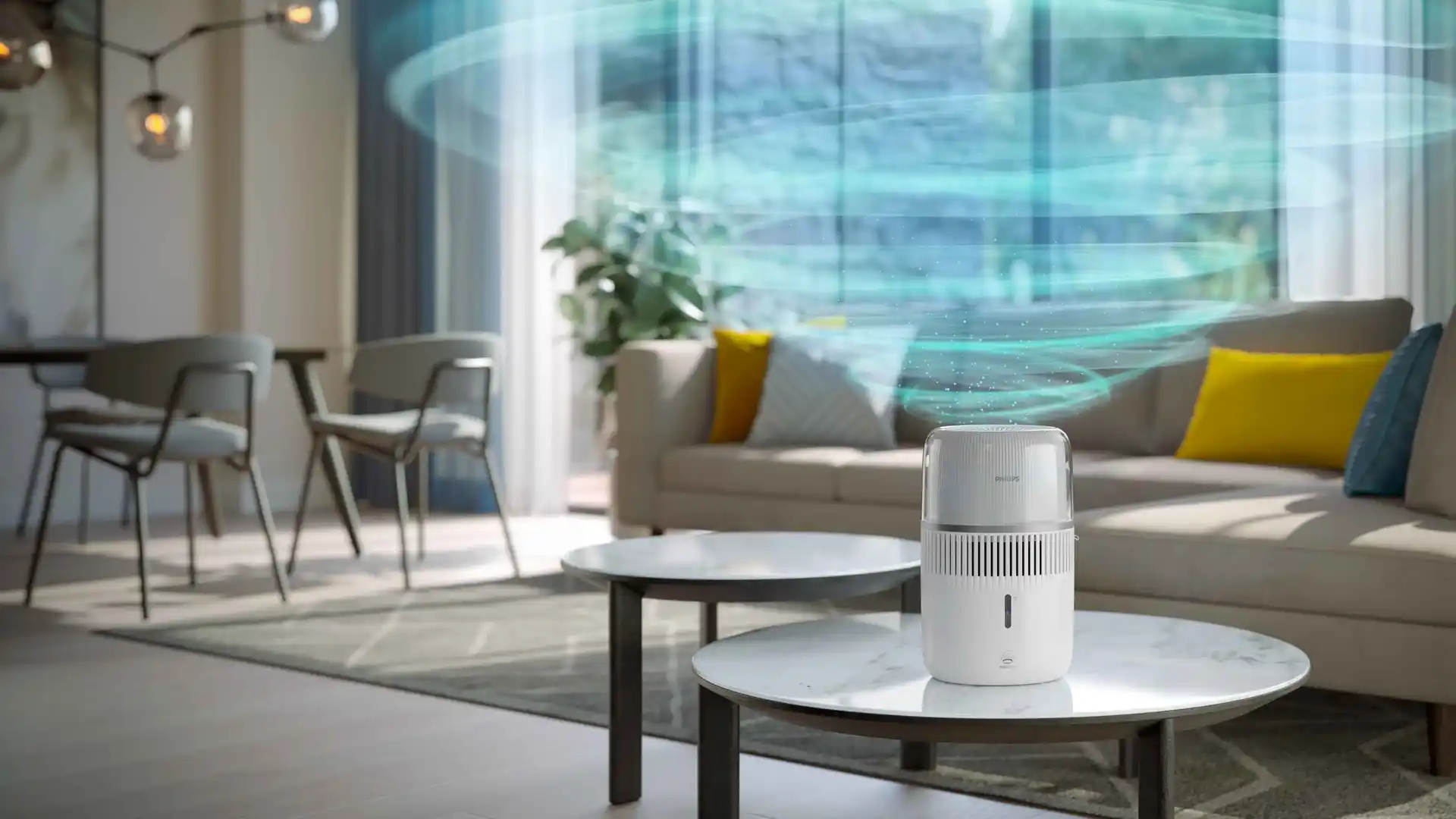 Philips Climate Care gaisa attīrītājs uz marmora galda, stilīgā viesistabā. Filtrs rada dzidru, virpuļojošu strūklu, kas padara mājas redzami tīrākas.