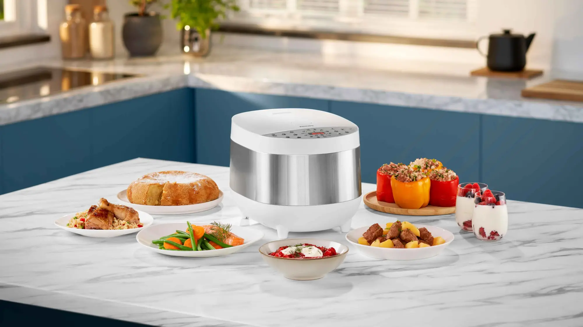 Philips plīts līnija: multivārāmais katls ar digitālo displeju, matēta tērauda korpusu un baltu virsmu, ap kuru gatavo gardas maltītes, demonstrējot izcilu dizainu un lietotāja pieredzi.