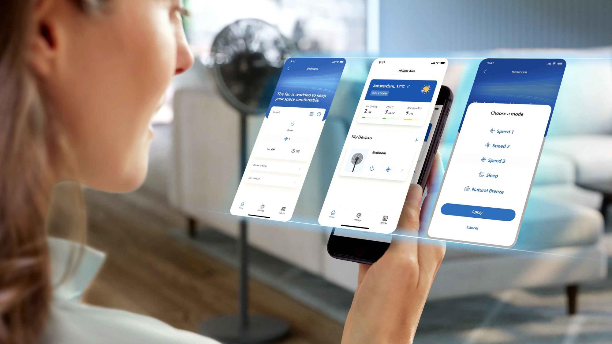 Kontrolējiet Philips dzesēšanas ventilatoru, izmantojot mobilo lietotni, lai nodrošinātu optimālu klimata kontroli. Sieviete regulē ventilatora ātrumu un iestatījumus, uzraugot gaisa kvalitāti un temperatūru telpās.
