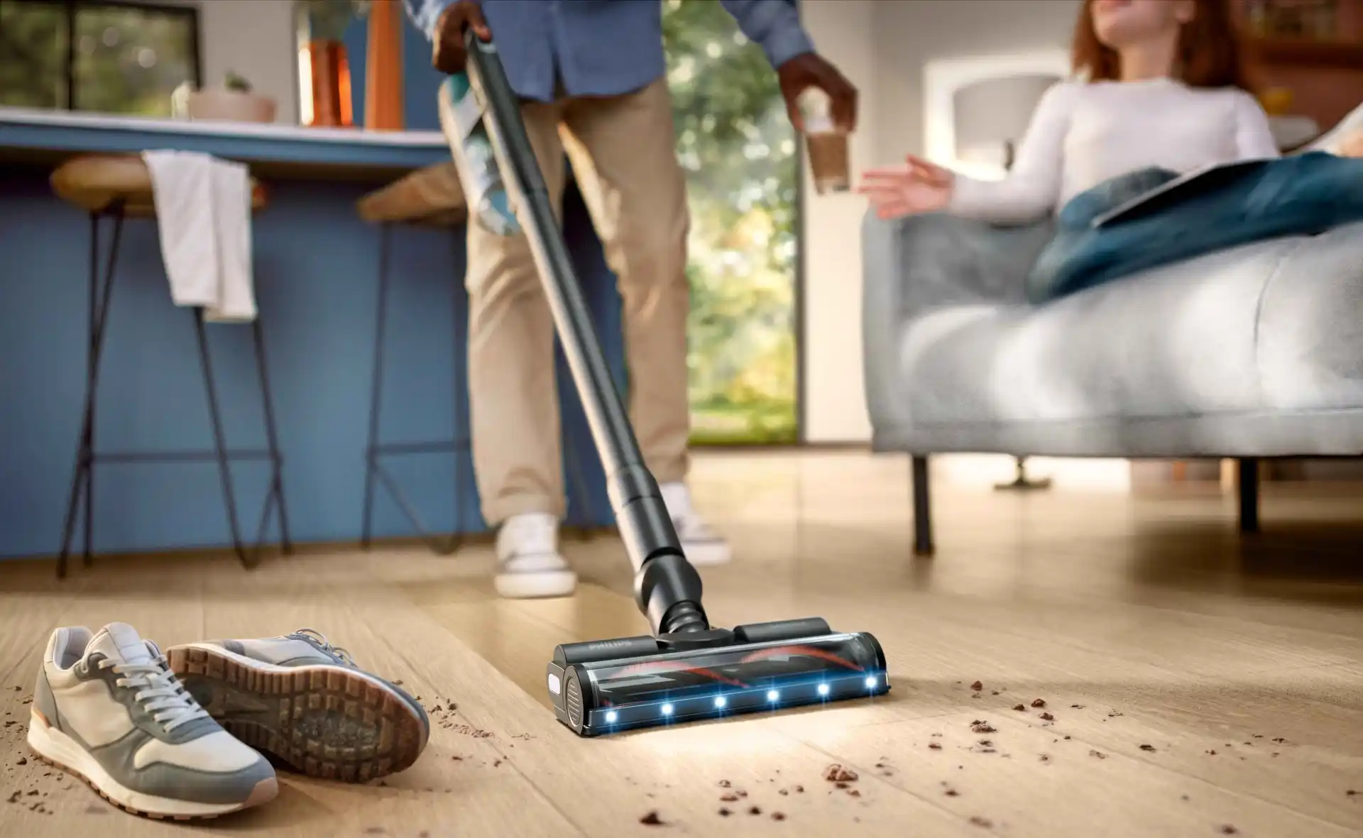 Philips grīdas kopšana: bezvada spieķa tipa putekļsūcējs ar LED gaismām uz uzgaļa efektīvi tīra gružus no cietkoksnes, izceļot Philips modernāko grīdas kopšanas tehnoloģiju.