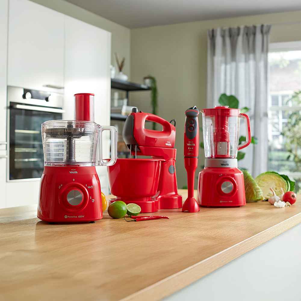 Food-Prep-9-fr Philips Food Prep līnija, kurā redzams sarkans virtuves kombains, rokas mikseris, iegremdējamais blenderis un blenderis uz koka virsmas. Radīts veiktspējai un stilam, uzlabojot jūsu virtuves pieredzi.