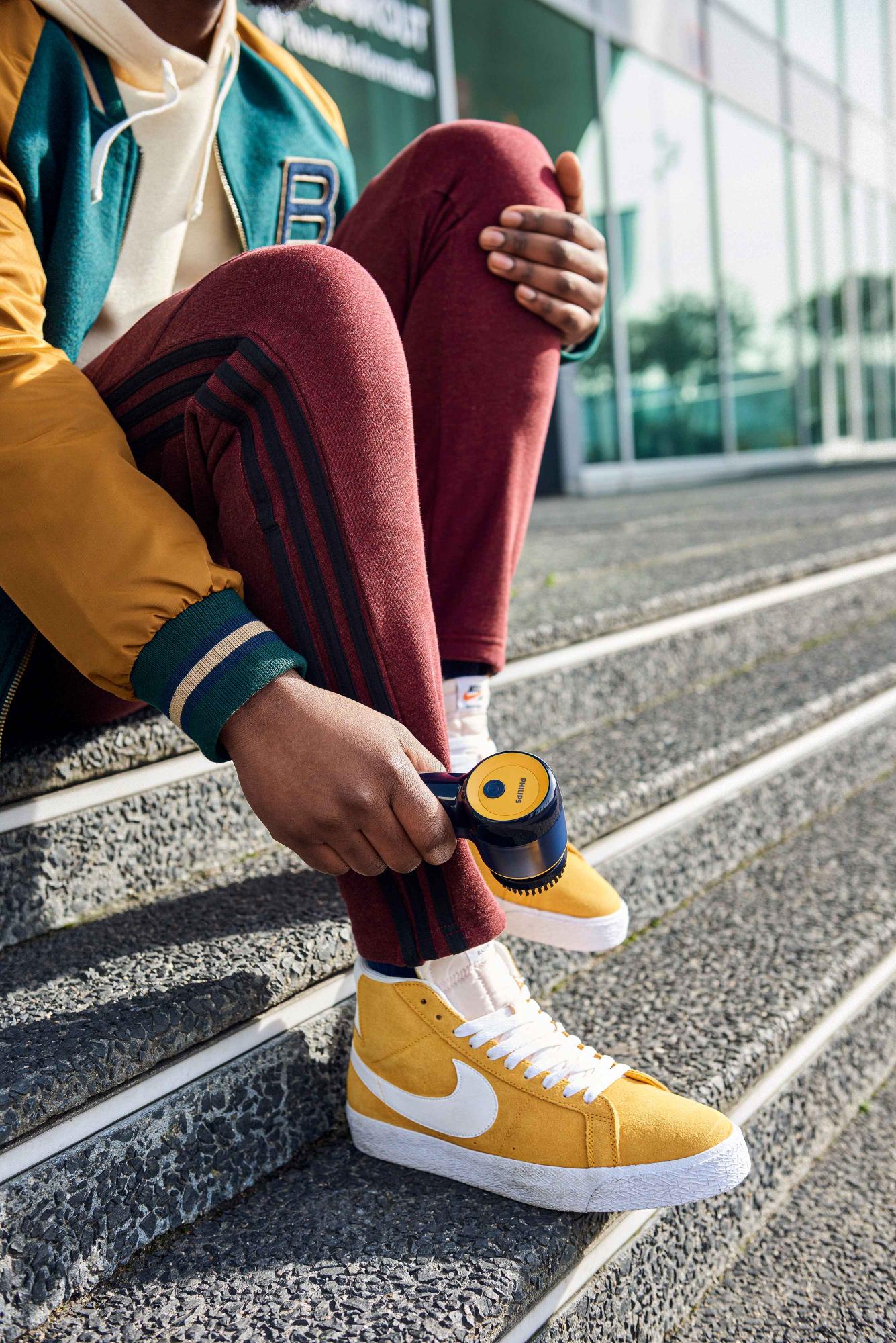 Philips Garment Care auduma skuveklis tumši zilā un dzeltenā krāsā, tiek izmantots dzeltenu sporta apavu kopšanai. Izceļot tā efektivitāti apģērbu kopšanā, pozējot brīvā dabā.