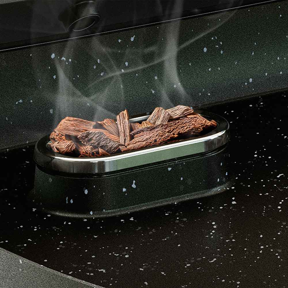 Kūpinošu koka skaidu tuvplāns Philips grila un tostera ovālā paplātē, izceļot inovatīvo kūpināšanas funkciju.