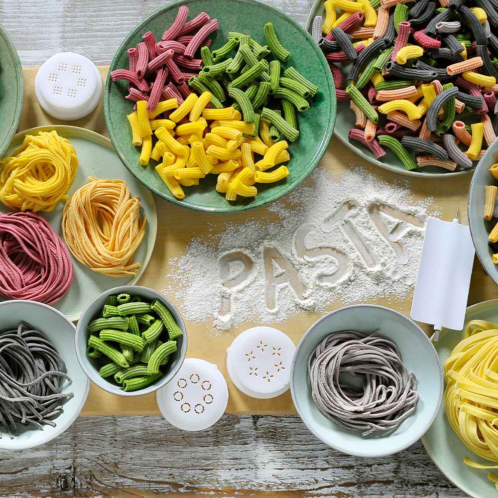 Virs galvas svaigi darināti Philips pastas gatavotāji. Bļodās un šķīvjos attēloti spilgti makaroni ap miltos uzrakstīto "PASTA". Philips pastas spiedes norāda uz izcilu mājās gatavotu makaronu pieredzi.