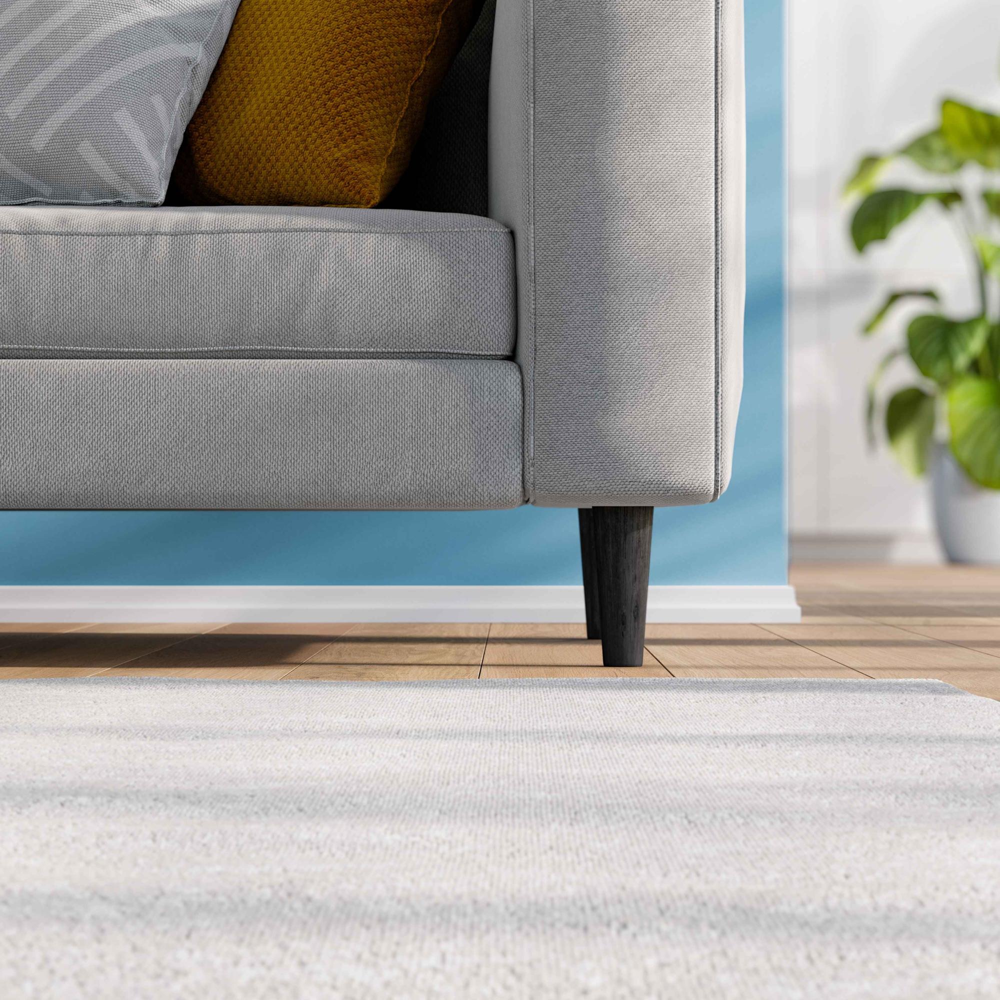 hilips traipu tīrītāja reklāmas attēls. Philips traipu tīrītāju līnija nodrošina izcilus rezultātus un ir redzama uz tīra, mīksta paklāja. Dīvāns rada mājīgu atmosfēru, demonstrējot izcilas tehnoloģijas grīdas kopšanā.