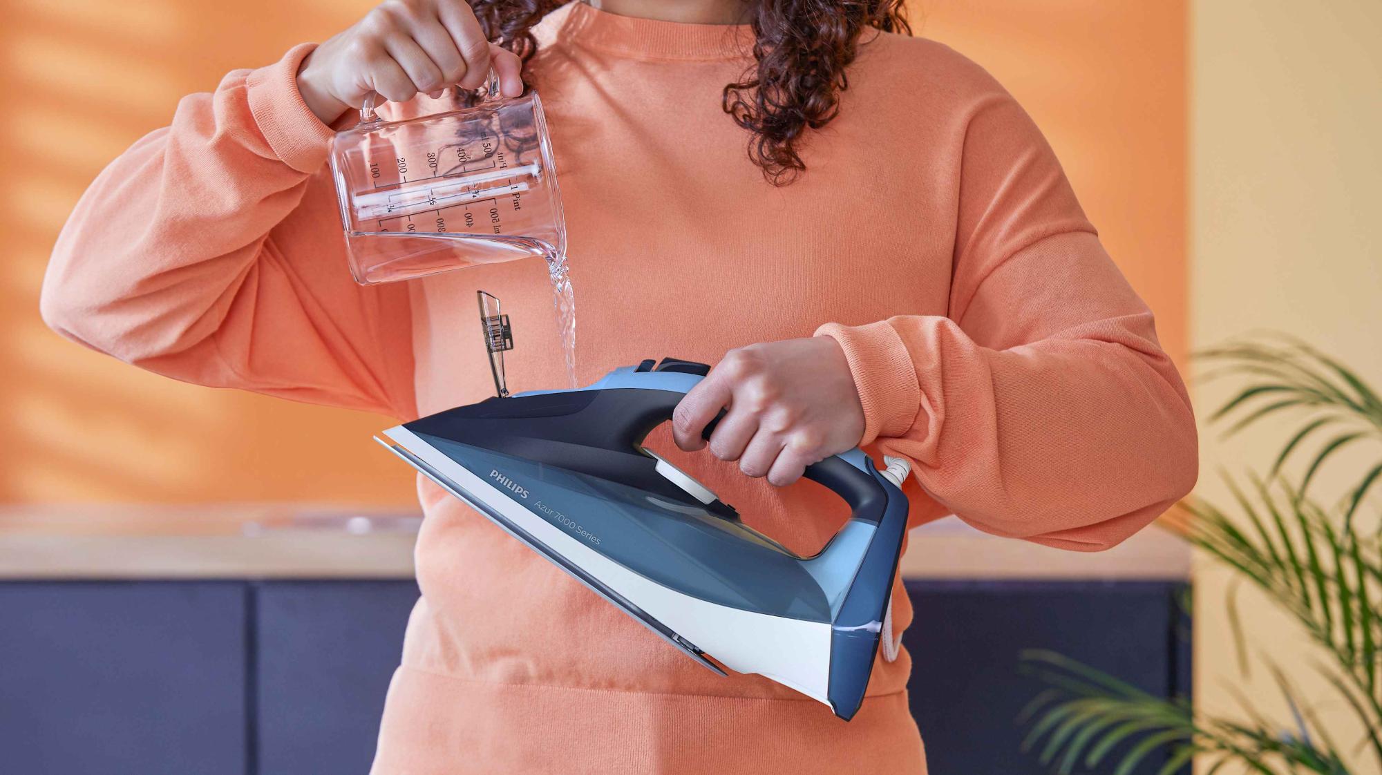 Philips tvaika gludekļa Azur 7000 sērijas modeļa piepildīšana ar ūdeni. Šis tvaika gludeklis ir Philips apģērbu kopšanas virsotne, piedāvājot izcilu sniegumu.