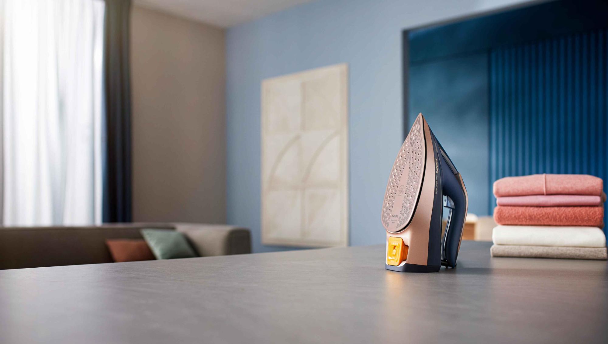 Philips tvaika gludekļi: augstākās klases gludeklis stāv blakus nevainojami salocītiem audumiem. Dizains apvieno progresīvas tehnoloģijas ar modernu estētiku, lai nodrošinātu izcilu gludināšanu.