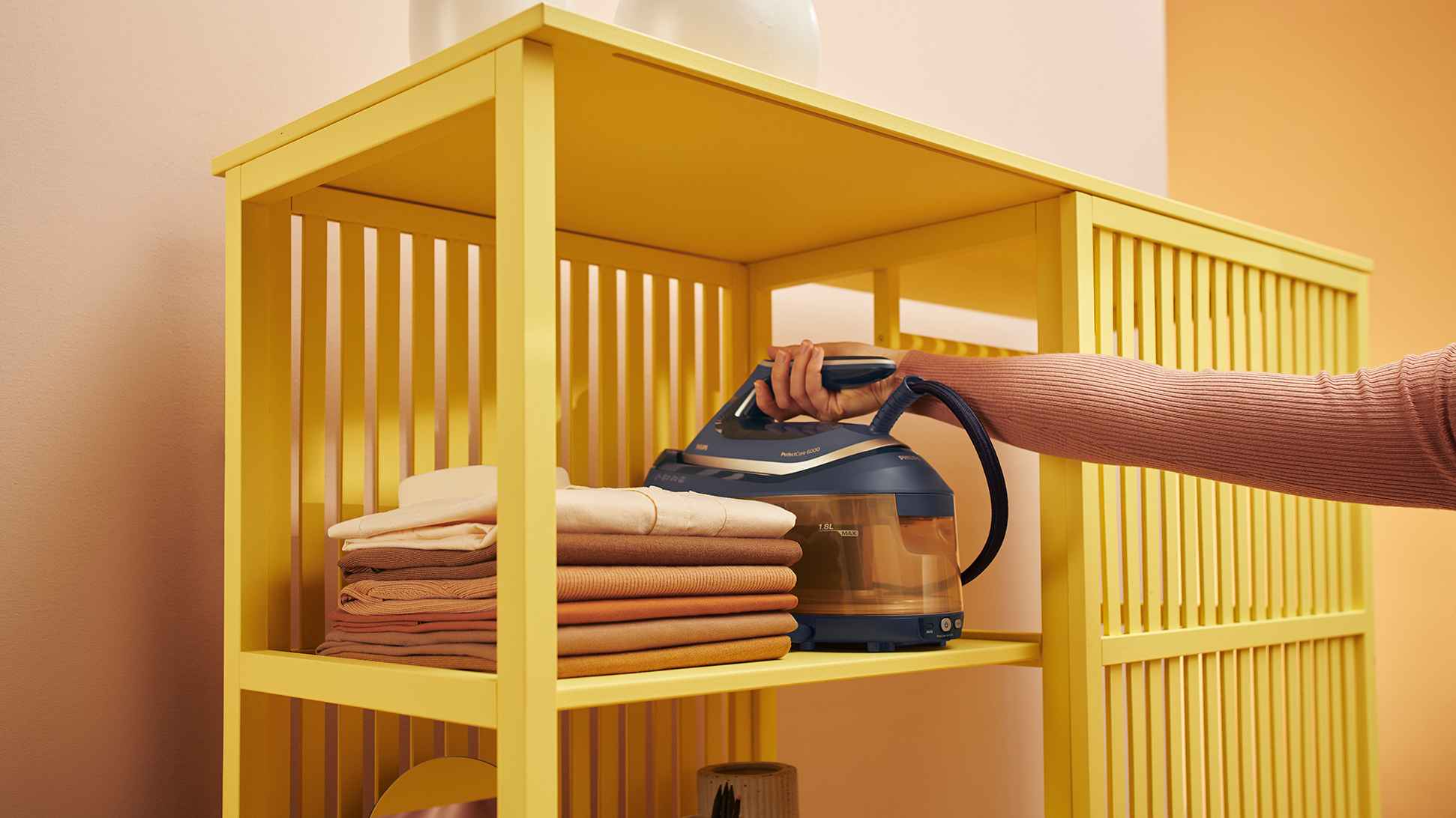 Philips tvaika ģeneratora gludekļa sistēma — augstākās kvalitātes apģērbu kopšanas līdzeklis, kas novietots uz plaukta ar drēbēm. Paredzēts izciliem gludināšanas rezultātiem.