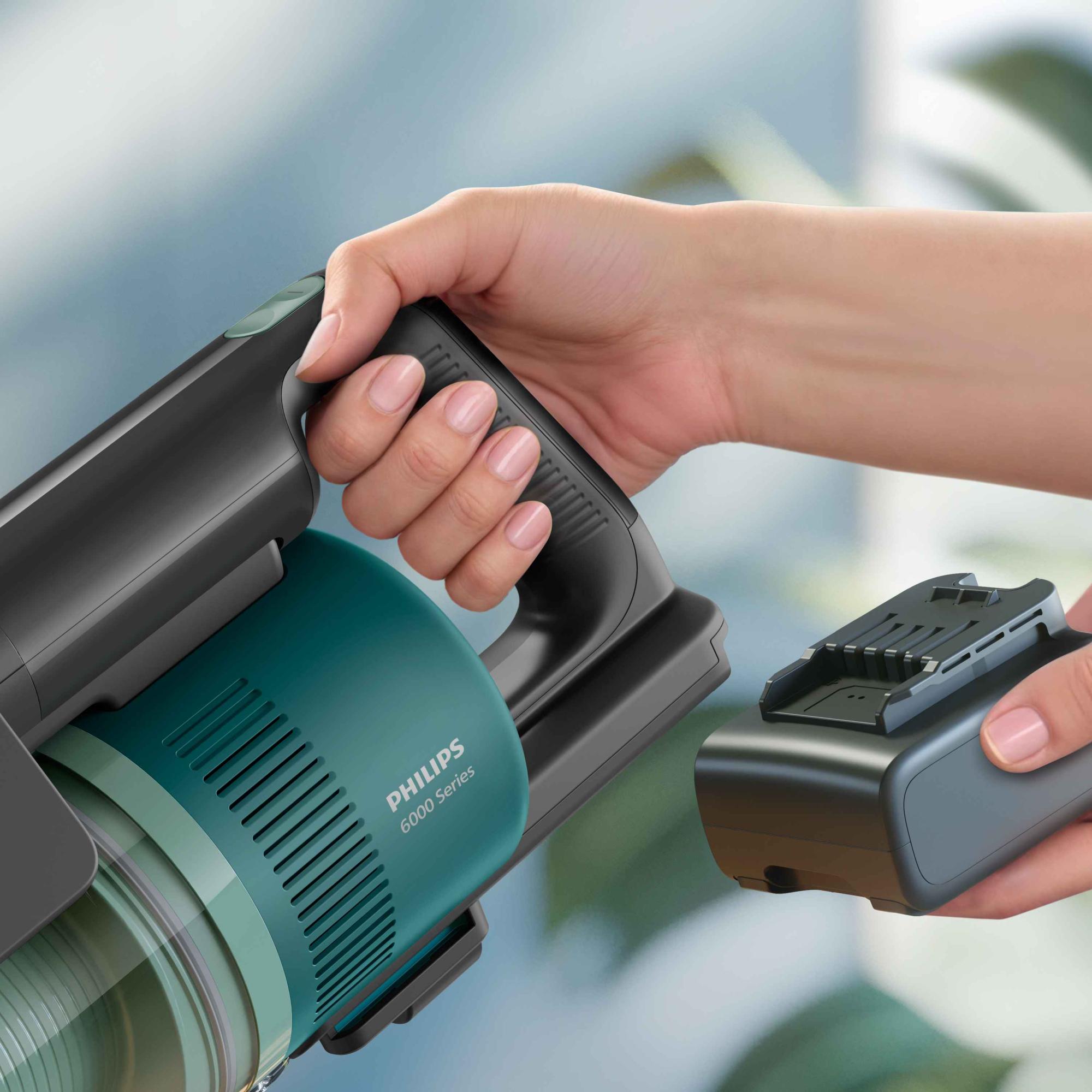 Philips Sticks sērija: bezvadu putekļsūcējs ar jaudīgu sūkšanas jaudu elegantā, zilganzaļā dizainā. Rokā redzams noņemams akumulators. Izbaudiet labāko no Philips Floor Care.