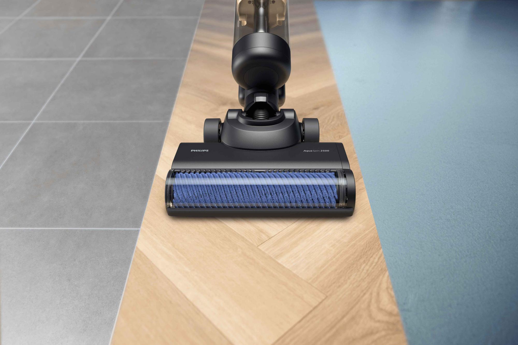 Tuvplāns ar melnu Philips Vac & Wash putekļsūcēju ar AquaSpin 2500, kas efektīvi tīra flīžu, masīvkoka un paklāju virsmas.