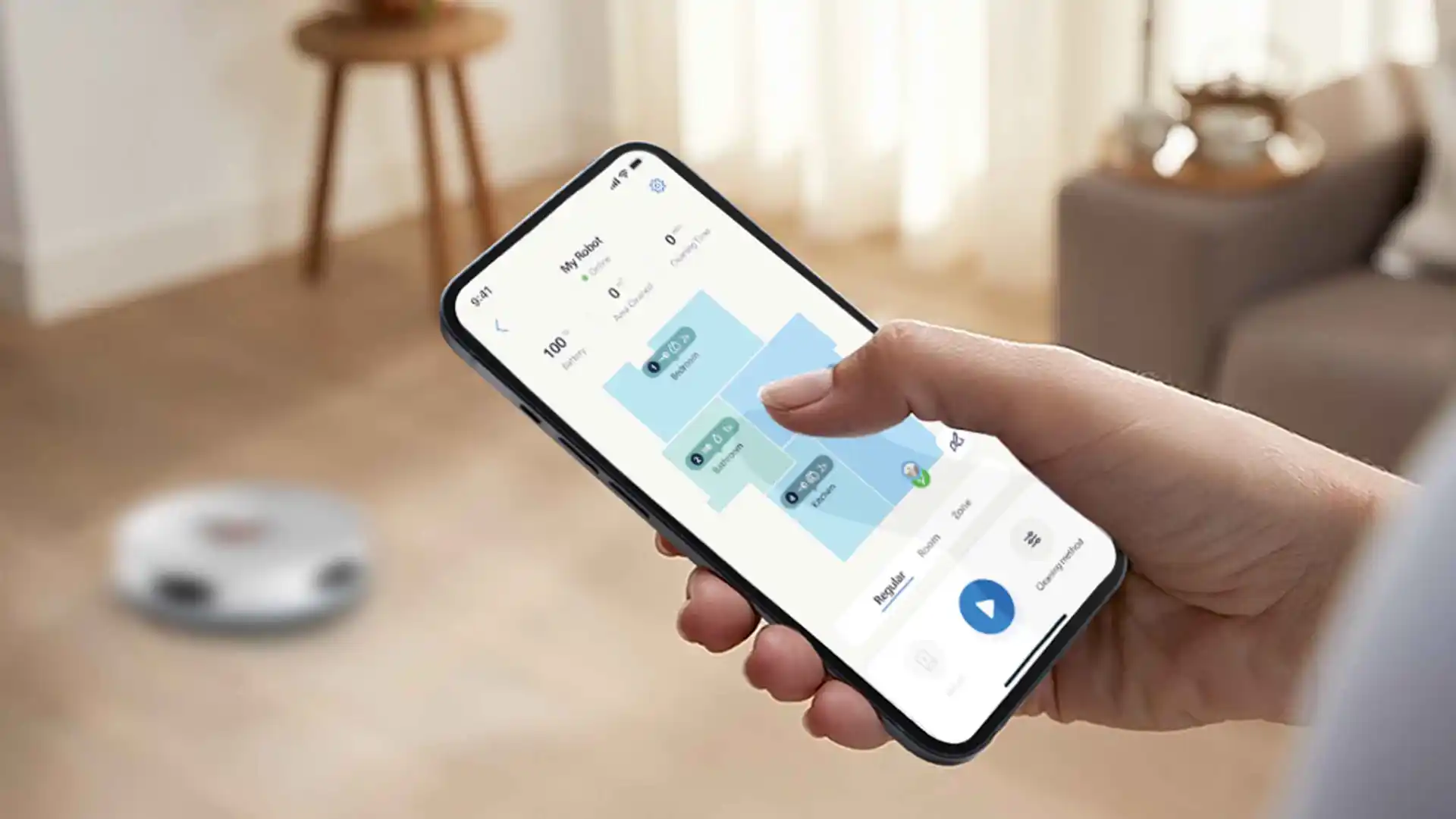 Cilvēks, kas izmanto tālruņa lietotni, lai vadītu Philips robotizēto putekļsūcēju — grīdas kopšanas virsotni, demonstrējot viedās mājas tehnoloģijas. Lietotnē tiek parādīta detalizēta mājas karte pielāgotai tīrīšanai.