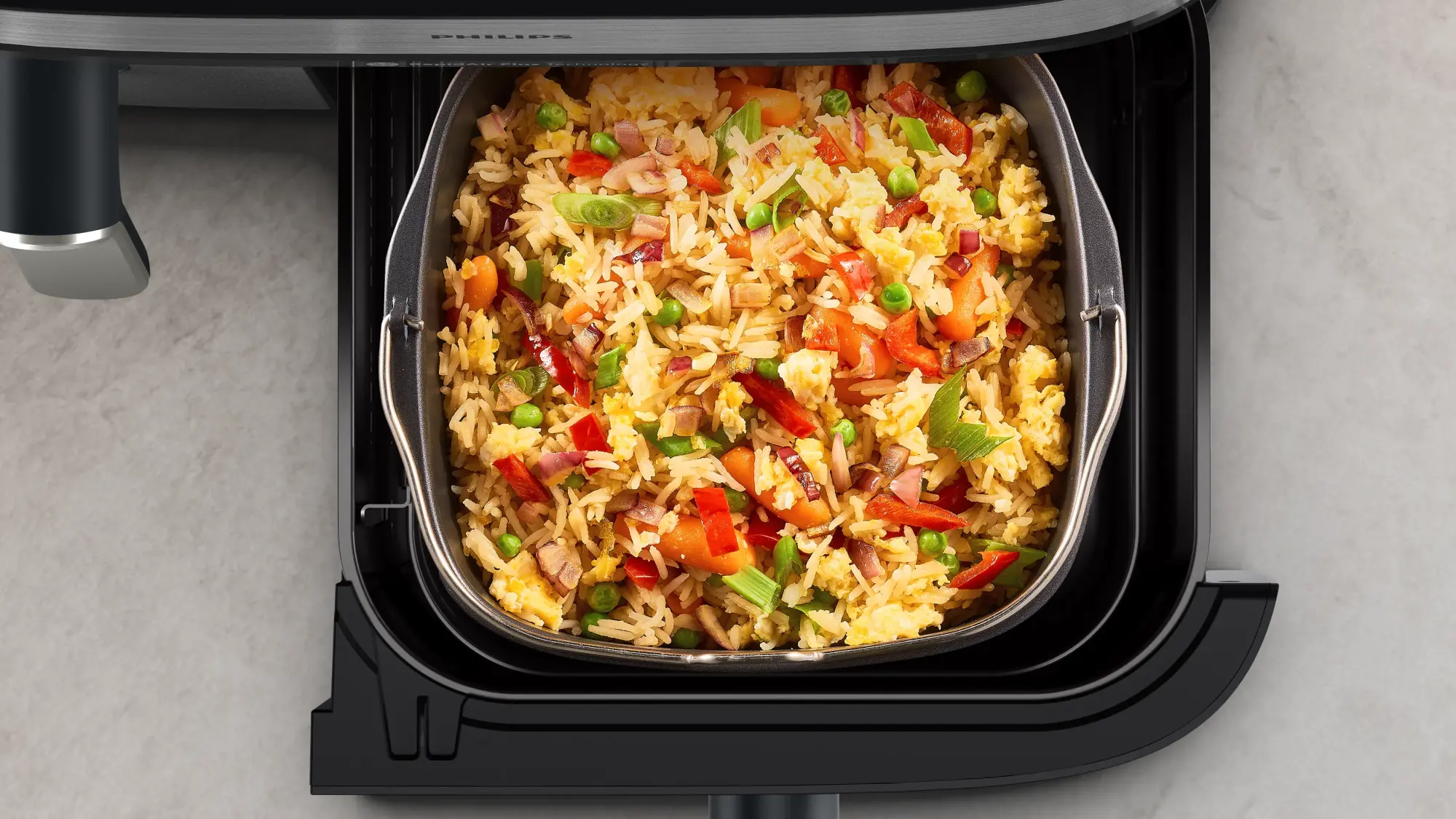 Uz letes novietots Philips divu grozu gaisa fritieri ar piederumiem un traukiem.